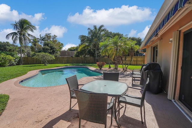 view of swimming pool featuring a patio, a grill, and a lawn