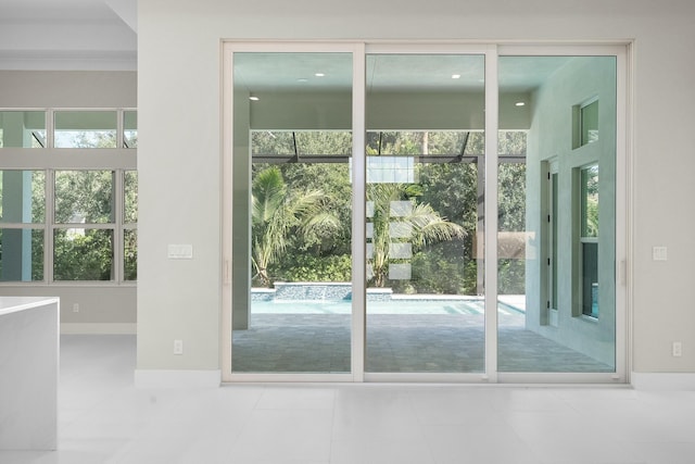 doorway with baseboards and tile patterned floors