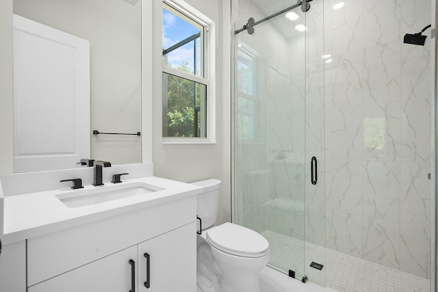 bathroom with vanity, a marble finish shower, and toilet