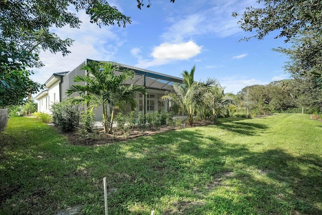 view of yard featuring a garage and glass enclosure