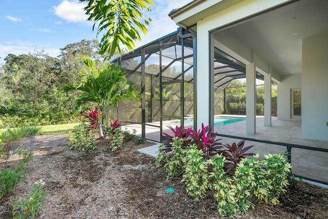 exterior space featuring a lanai, a patio area, and an outdoor pool