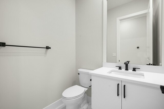 half bathroom with vanity and toilet