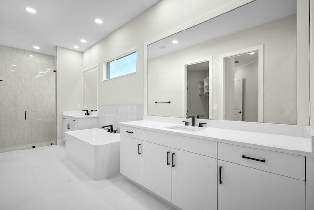 full bath with a freestanding bath, a marble finish shower, vanity, and recessed lighting