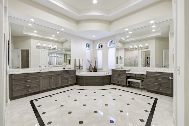 bathroom with a washtub, vanity, a tray ceiling, and ornamental molding