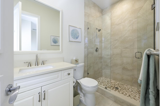 bathroom with tile patterned floors, vanity, toilet, and an enclosed shower