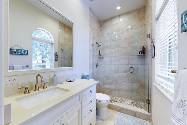 bathroom with vanity, tile patterned flooring, a shower with shower door, and toilet