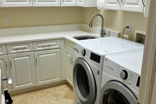 laundry area with cabinets, separate washer and dryer, and sink