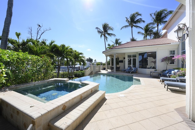 view of swimming pool featuring an in ground hot tub and a patio