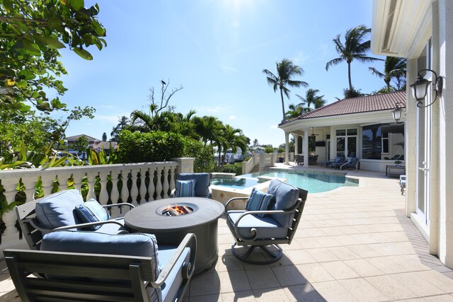 view of patio with an outbuilding, a fenced in pool, and a fire pit