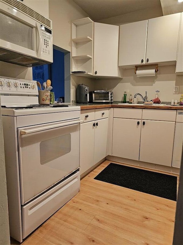 kitchen featuring white cabinetry, white appliances, and light hardwood / wood-style flooring