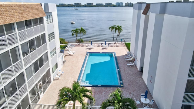 view of swimming pool featuring a patio and a water view