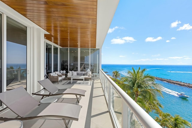 balcony featuring a water view and an outdoor hangout area