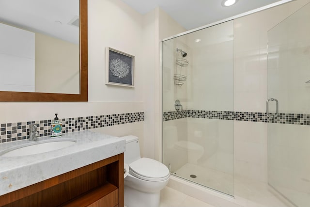 full bath featuring tile walls, a shower stall, toilet, and vanity