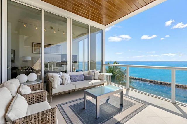 balcony with a beach view, outdoor lounge area, and a water view