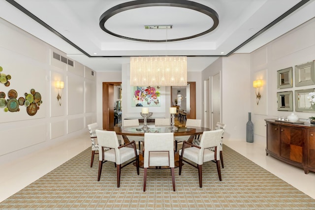 dining area with a raised ceiling, visible vents, and a decorative wall