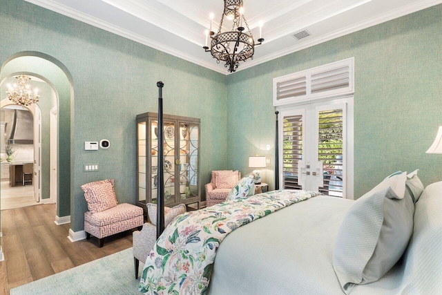 bedroom with dark wood-type flooring, crown molding, a chandelier, and access to outside