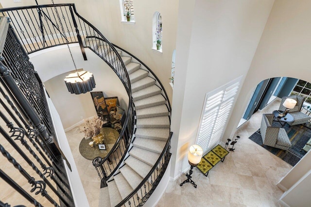 stairway with a towering ceiling and plenty of natural light