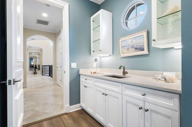 bathroom with ornamental molding, hardwood / wood-style floors, and vanity