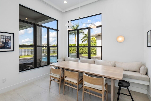 tiled dining room featuring breakfast area and a water view