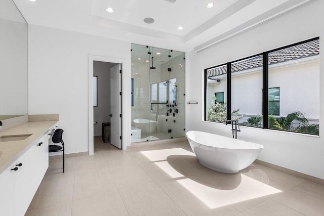 bathroom with vanity, shower with separate bathtub, tile patterned flooring, and a tray ceiling