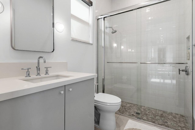 bathroom featuring walk in shower, vanity, and toilet