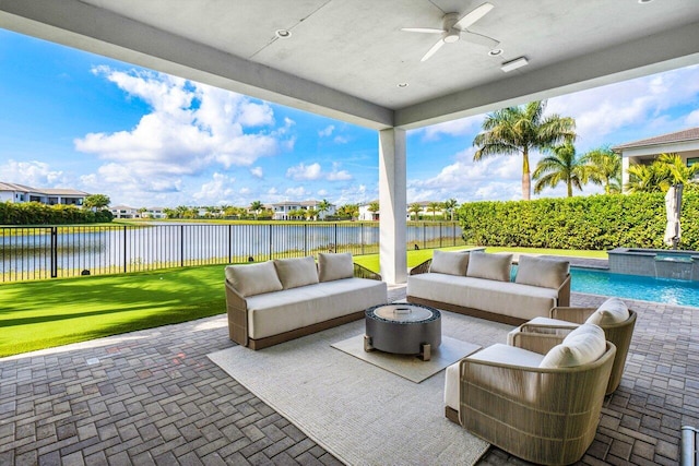 view of patio / terrace featuring an outdoor living space, a water view, a fenced in pool, and ceiling fan