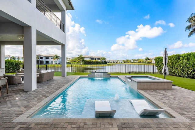 view of swimming pool with an in ground hot tub, pool water feature, a patio, and a water view