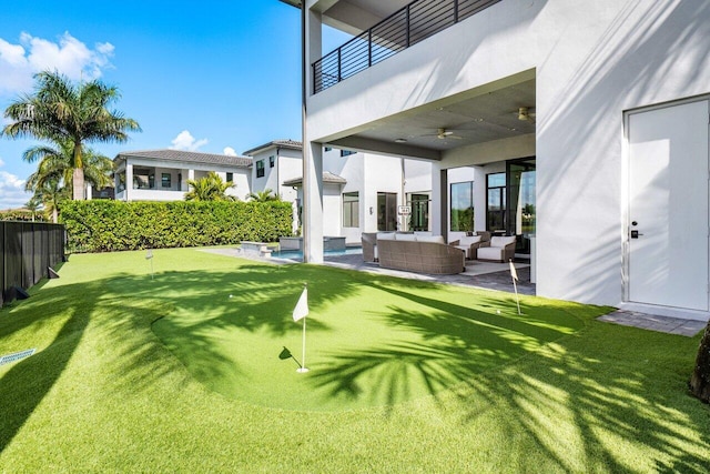 view of yard featuring an outdoor living space, a patio, a balcony, and ceiling fan