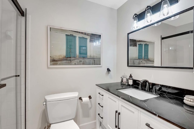 bathroom featuring vanity, walk in shower, and toilet