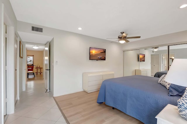 tiled bedroom featuring ceiling fan and a closet