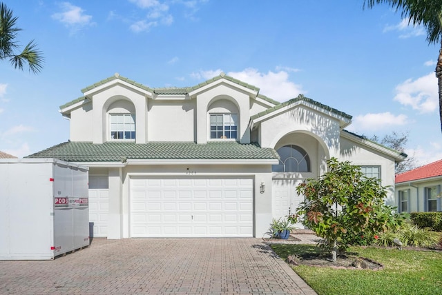 4209 Bahia Isle Cir, Wellington, FL 33449 - mediterranean / spanish house featuring a garage, stucco siding, a tiled roof, and driveway