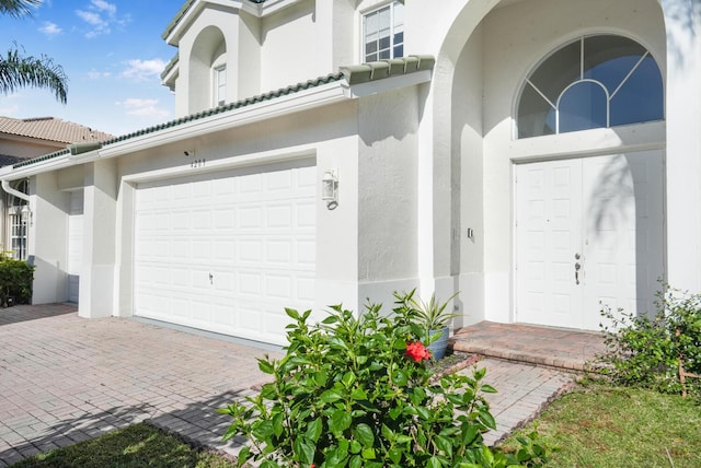 4209 Bahia Isle Cir, Wellington, FL 33449 - doorway to property featuring a garage, decorative driveway, stucco siding, and a tile roof