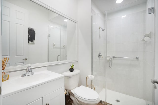 bathroom with an enclosed shower, vanity, and toilet