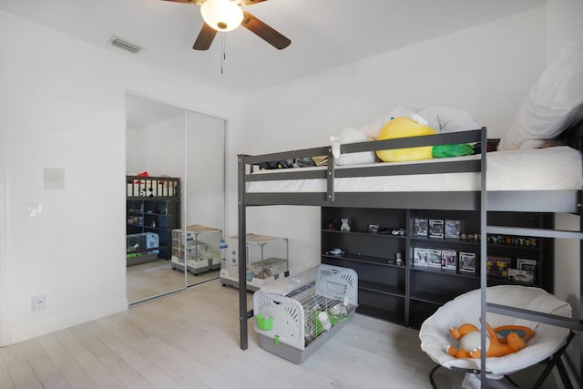 bedroom with hardwood / wood-style floors, ceiling fan, and a closet