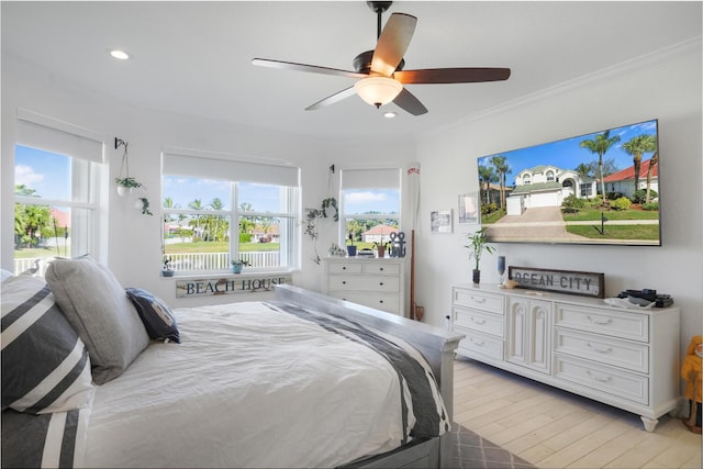 bedroom with multiple windows, crown molding, ceiling fan, and light hardwood / wood-style floors