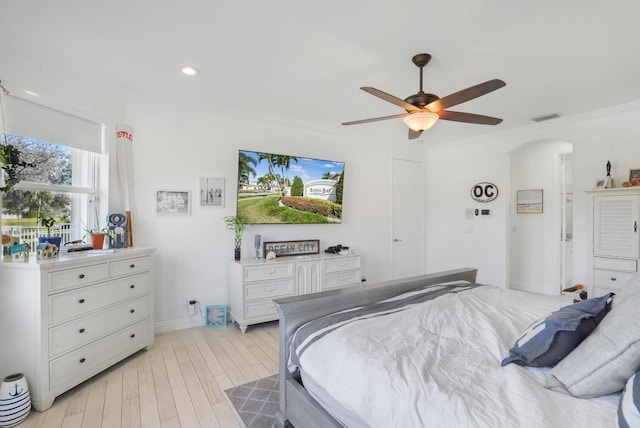 bedroom with crown molding, light hardwood / wood-style floors, and ceiling fan