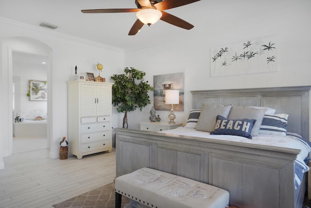 bedroom featuring ornamental molding, ceiling fan, light wood-type flooring, and ensuite bath