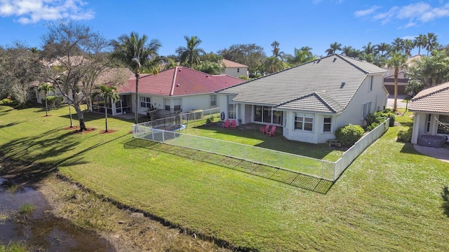 4209 Bahia Isle Cir, Wellington, FL 33449 - rear view of house featuring a lawn, fence, a tiled roof, and stucco siding