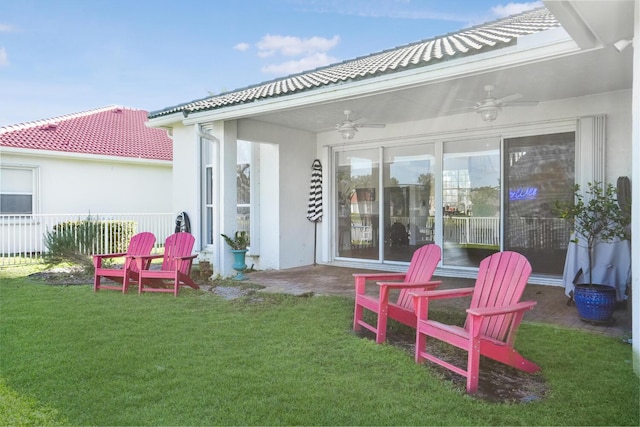 back of property featuring ceiling fan, a patio area, and a lawn