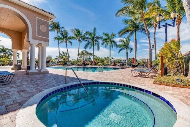 view of pool with a community hot tub and a patio area