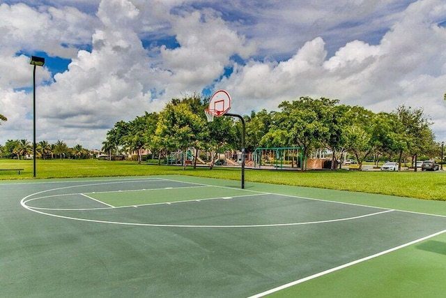 view of basketball court featuring a lawn and a playground