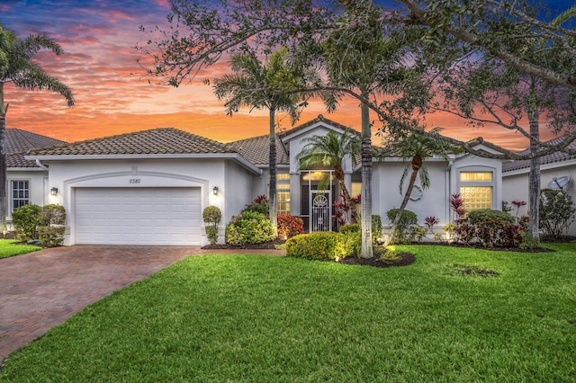 view of front of property featuring a garage and a yard