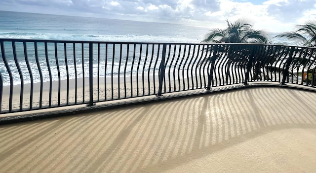 balcony featuring a water view and a beach view