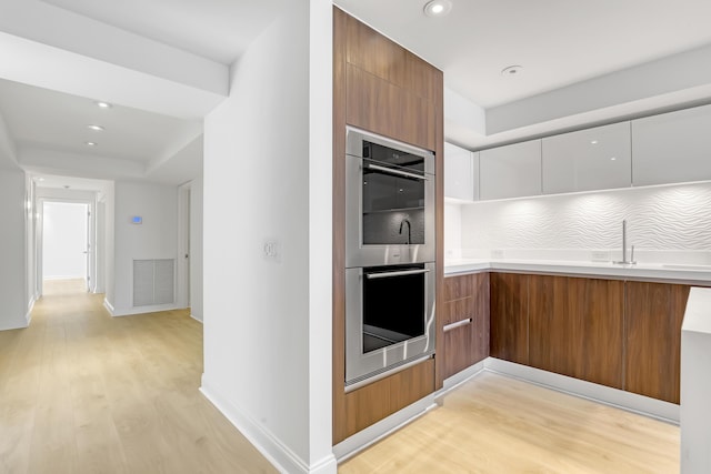 4000 S Ocean Blvd Unit 401, South Palm Beach, FL 33480 - kitchen with modern cabinets, double oven, light wood finished floors, and recessed lighting