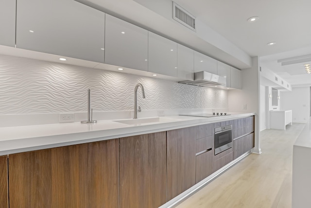4000 S Ocean Blvd Unit 401, South Palm Beach, FL 33480 - kitchen featuring modern cabinets, range hood, oven, black electric cooktop, and a sink