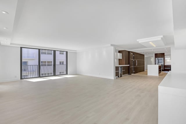 4000 S Ocean Blvd Unit 401, South Palm Beach, FL 33480 - unfurnished living room featuring light wood-type flooring and baseboards