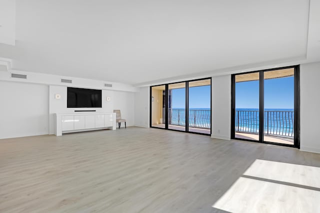 4000 S Ocean Blvd Unit 401, South Palm Beach, FL 33480 - unfurnished living room featuring light wood-style flooring and expansive windows