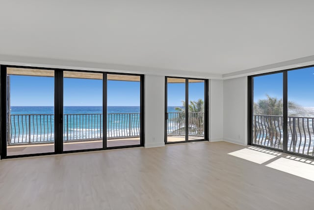 4000 S Ocean Blvd Unit 401, South Palm Beach, FL 33480 - empty room with wood finished floors, a water view, expansive windows, and baseboards