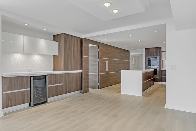 4000 S Ocean Blvd Unit 401, South Palm Beach, FL 33480 - kitchen featuring modern cabinets, beverage cooler, light wood-style flooring, recessed lighting, and light countertops
