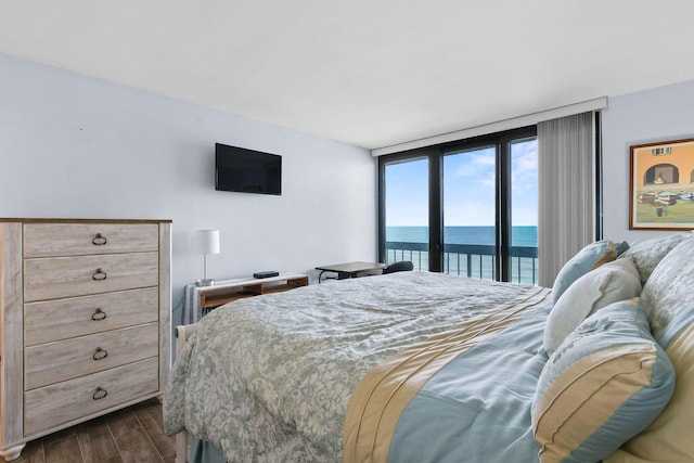 bedroom with access to exterior, a wall of windows, and dark hardwood / wood-style floors